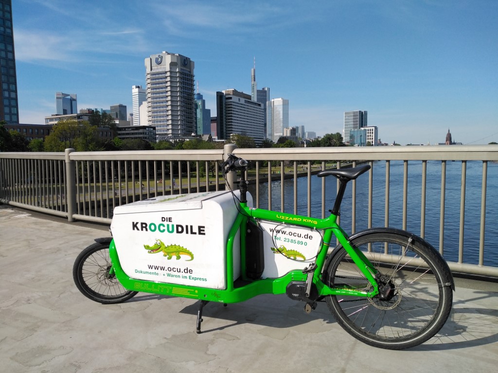 OCU Bike-Kurier – Krocudile Lastenrad am Main mit Frankfurter Skyline